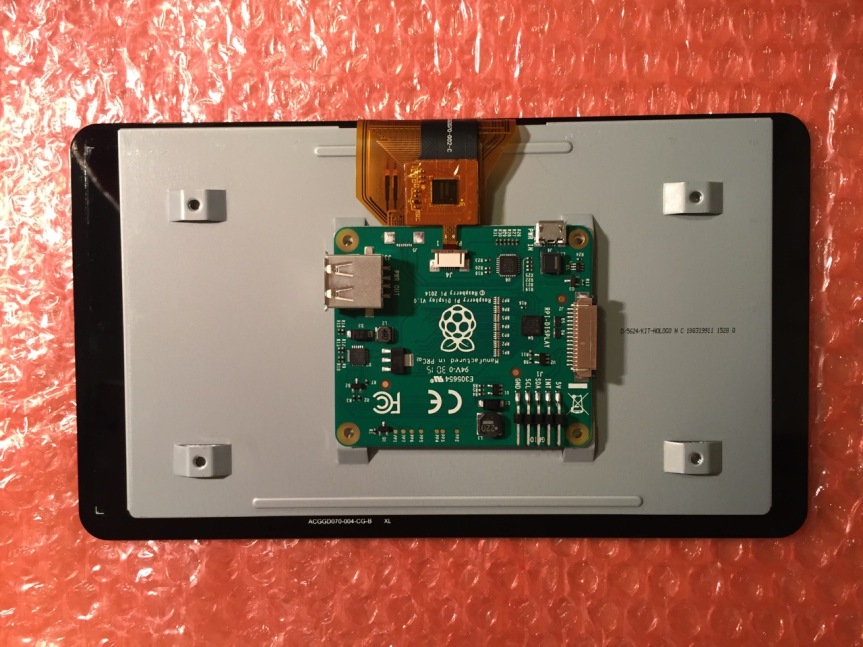 To begin connecting the 7" Touchscreen Display to the Raspberry Pi, place the screen facing down.