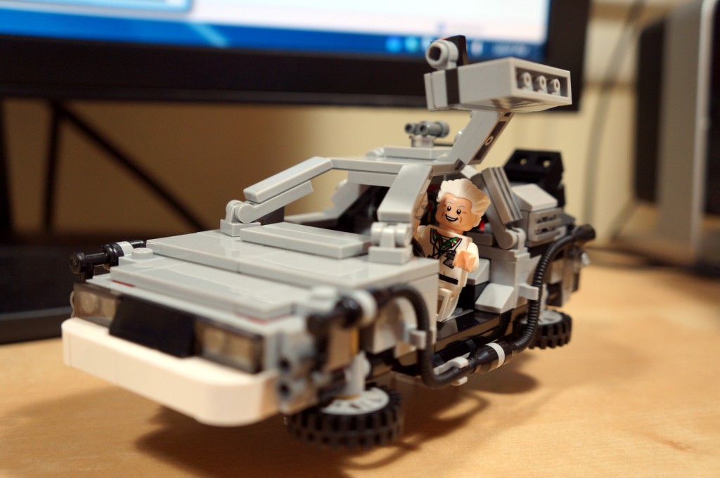 LEGO time travel DeLorean with the driver side door open and Doc Brown hanging out.